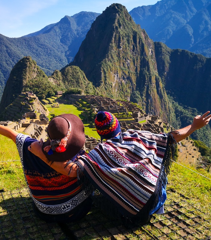 Beautiful couple admiring Machu Picchu mountain, Sacred Valley, and the surrounding peaks from above